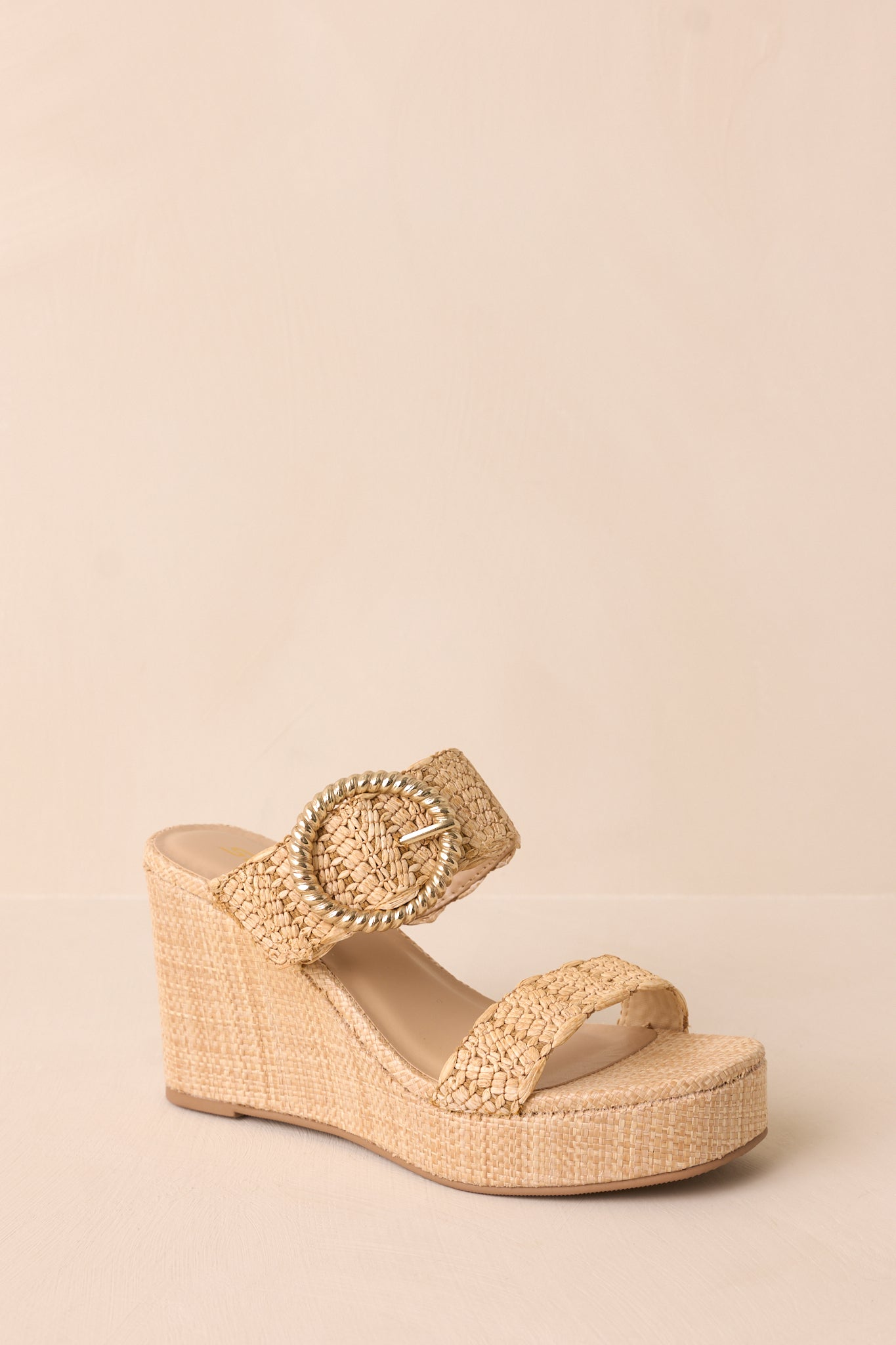 The natural wedges displayed at a side angle, showcasing the wedged heel, slip-on design, and gold buckle accents on the straps.