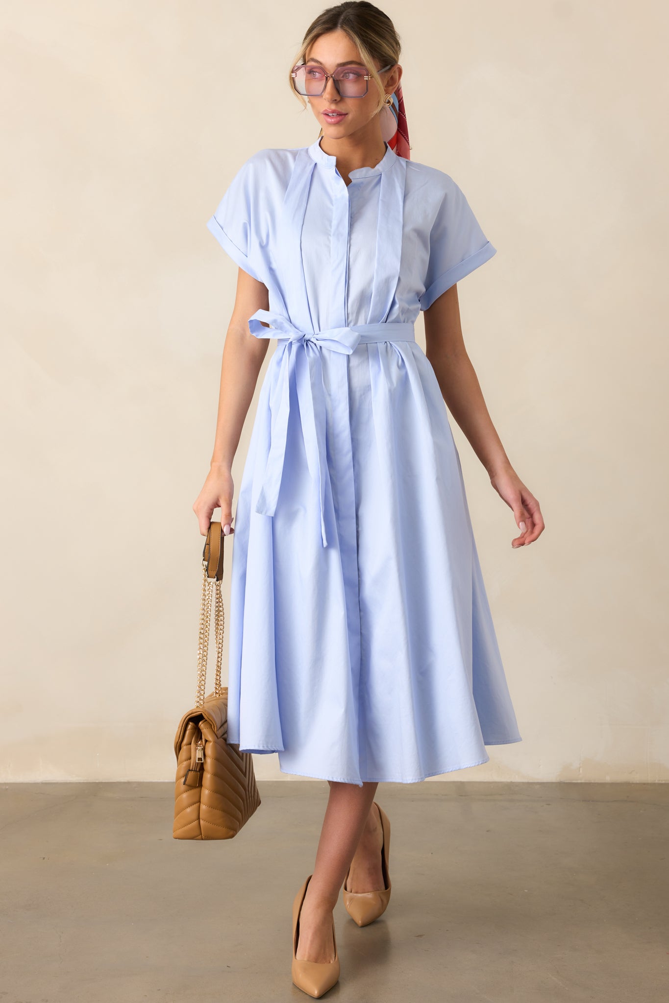 A sky blue dress with a functional button front, collared neckline, and a self-tie belt for a structured yet effortless look.