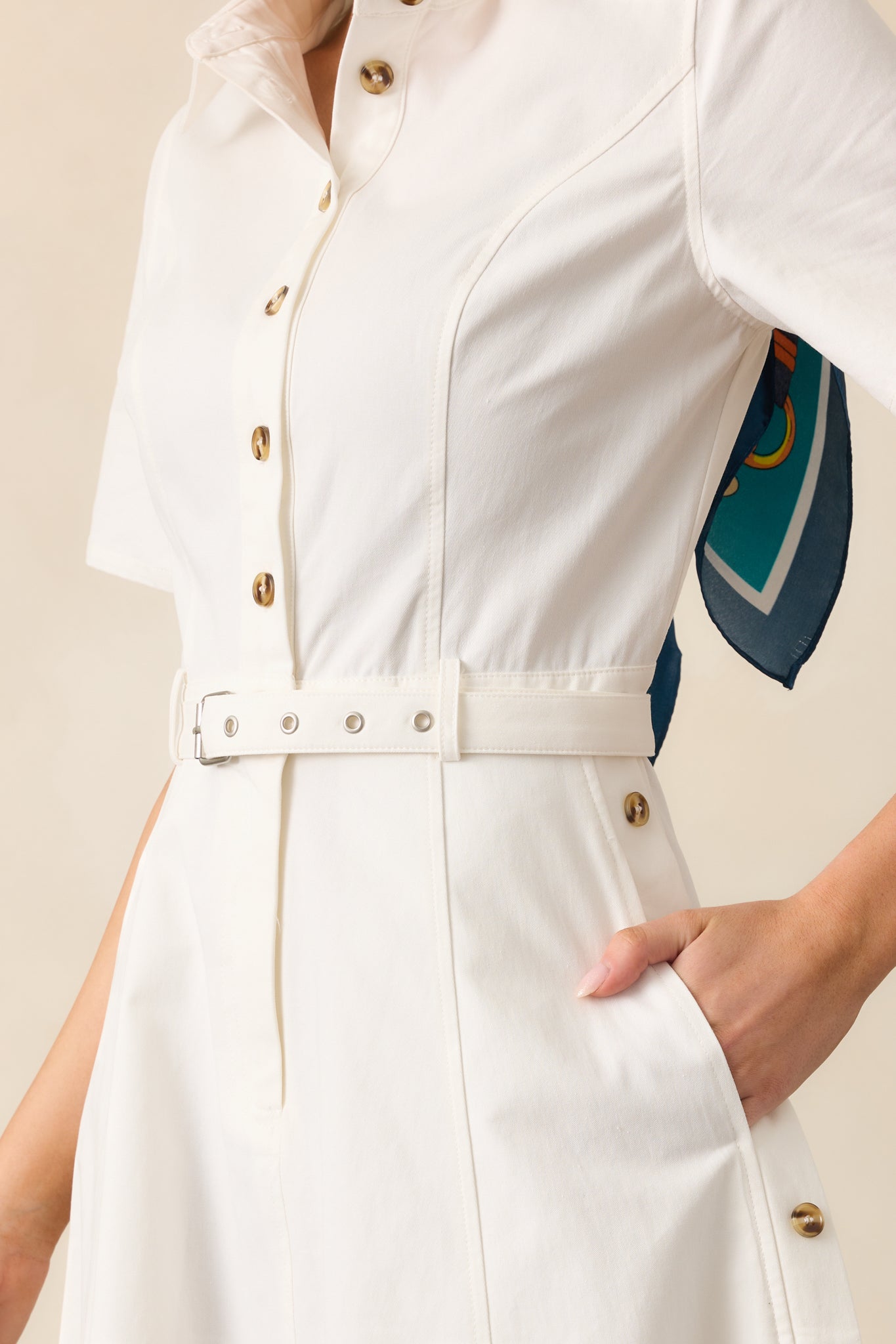 A closer look at the nonfunctional side buttons and structured fabric, showcasing the thoughtful design details of this white dress.
