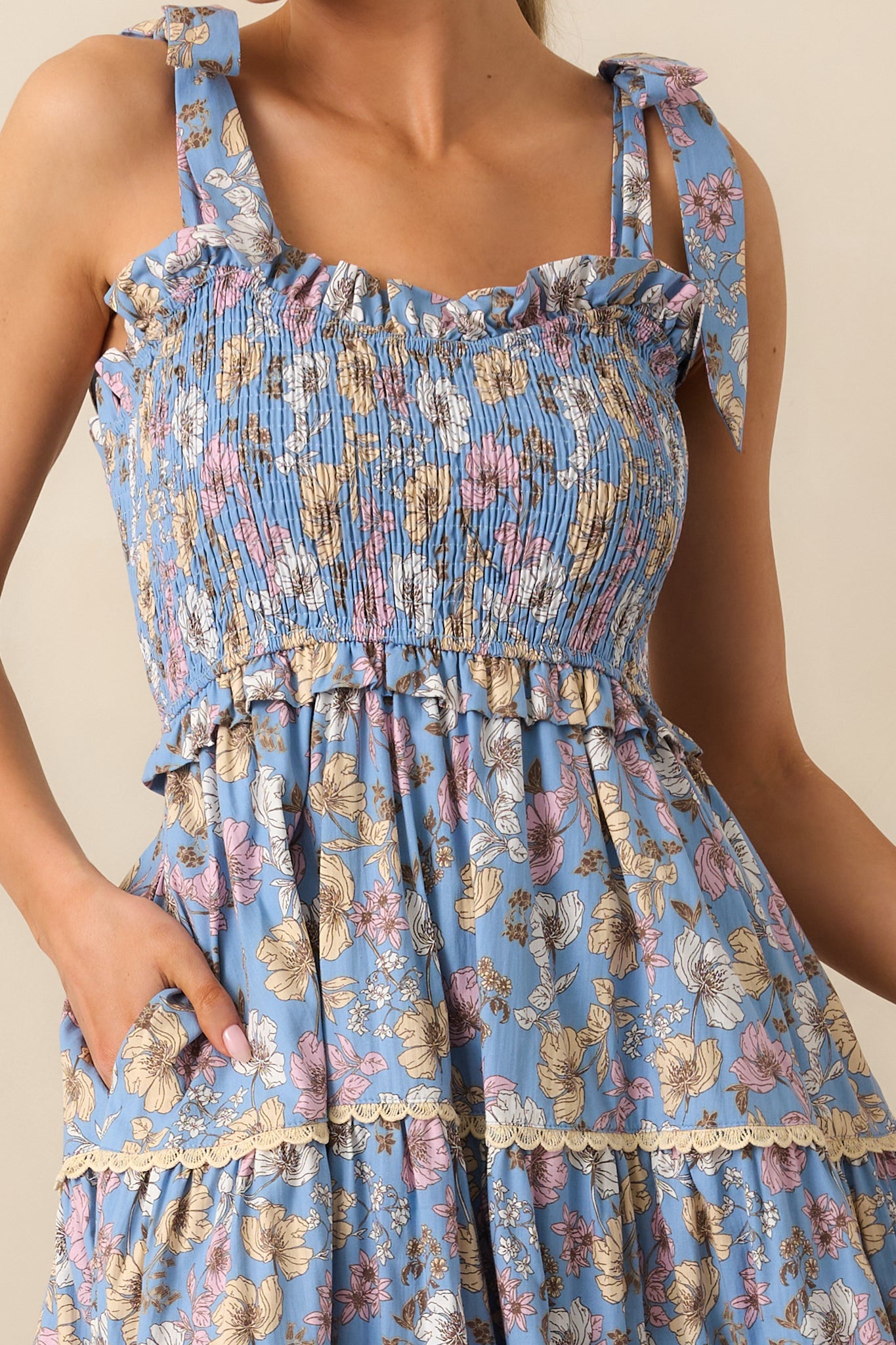 A detailed look at the ruffle details on the bodice and the floral print, paired with the lace texture of the tiered skirt for a charming finish.