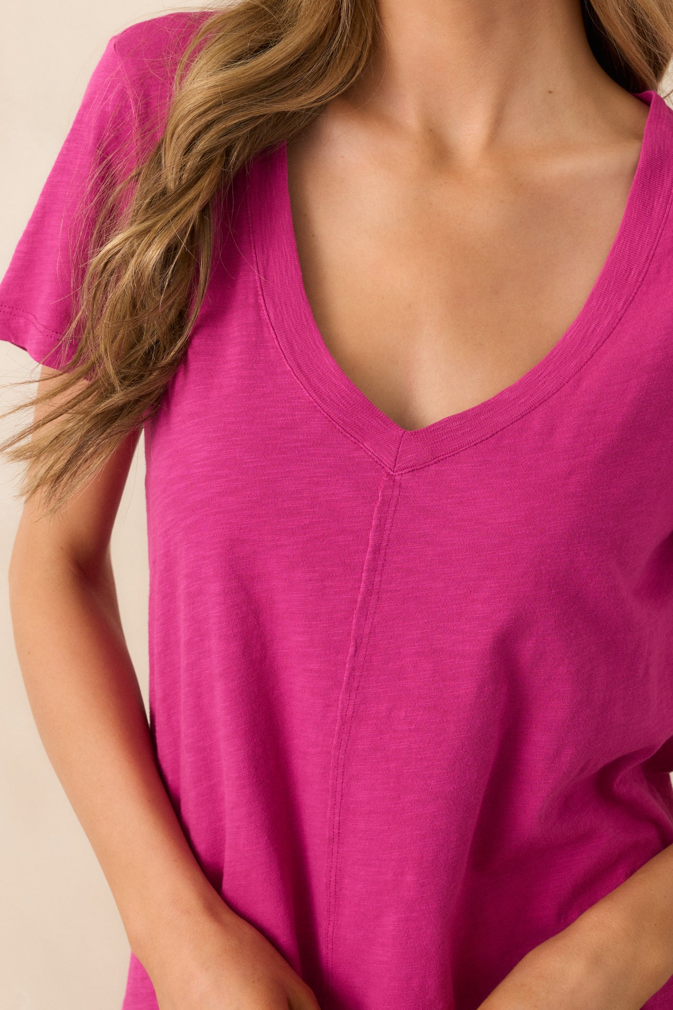 A close-up of the cotton slub fabric of the magenta top, revealing the subtle texture and the sleek, centered seams down the front and back.