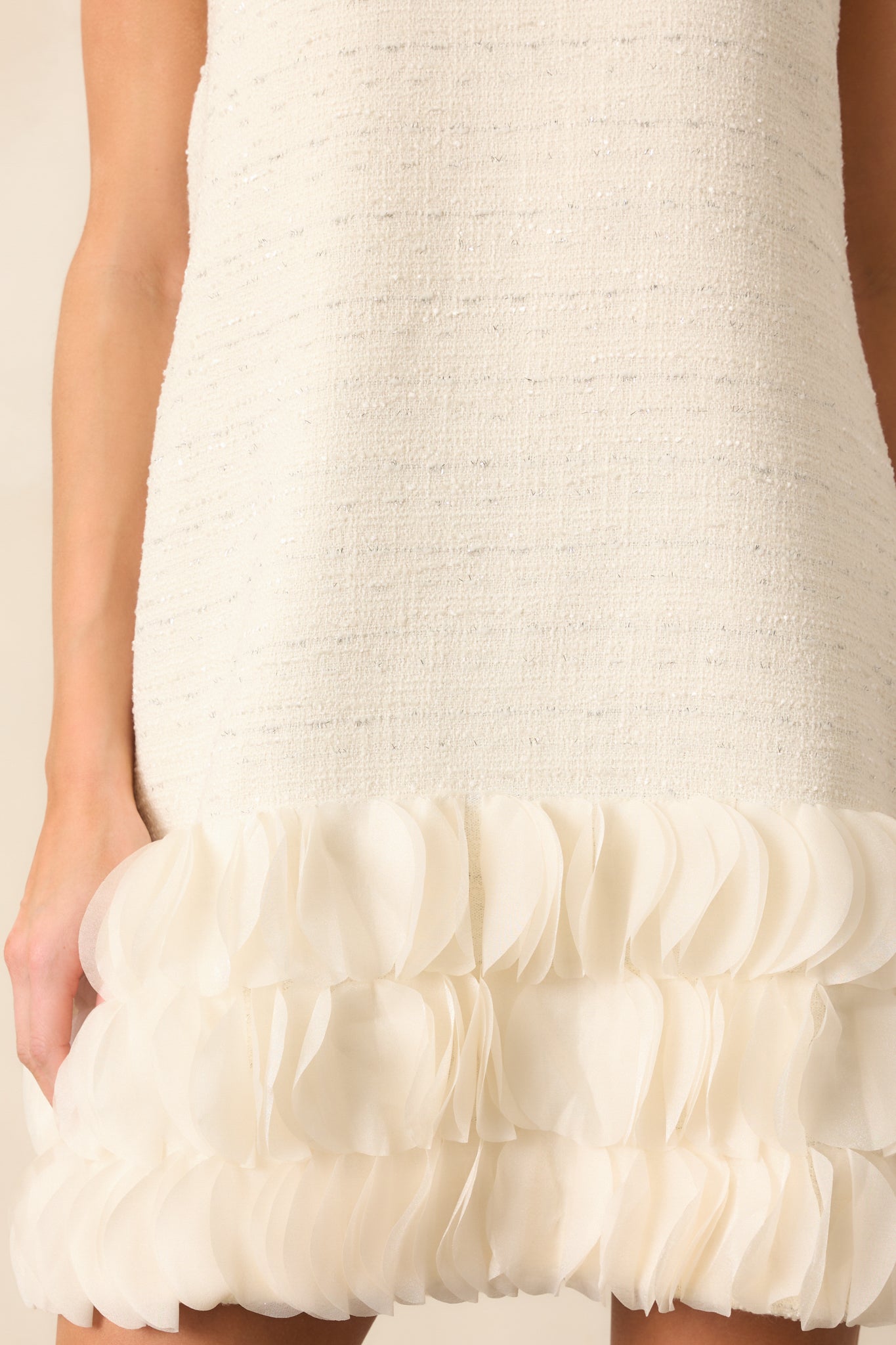 A zoomed-in shot of the ivory dress’s intricate 3D petal bottom tier, showcasing its layered and sculptural design.