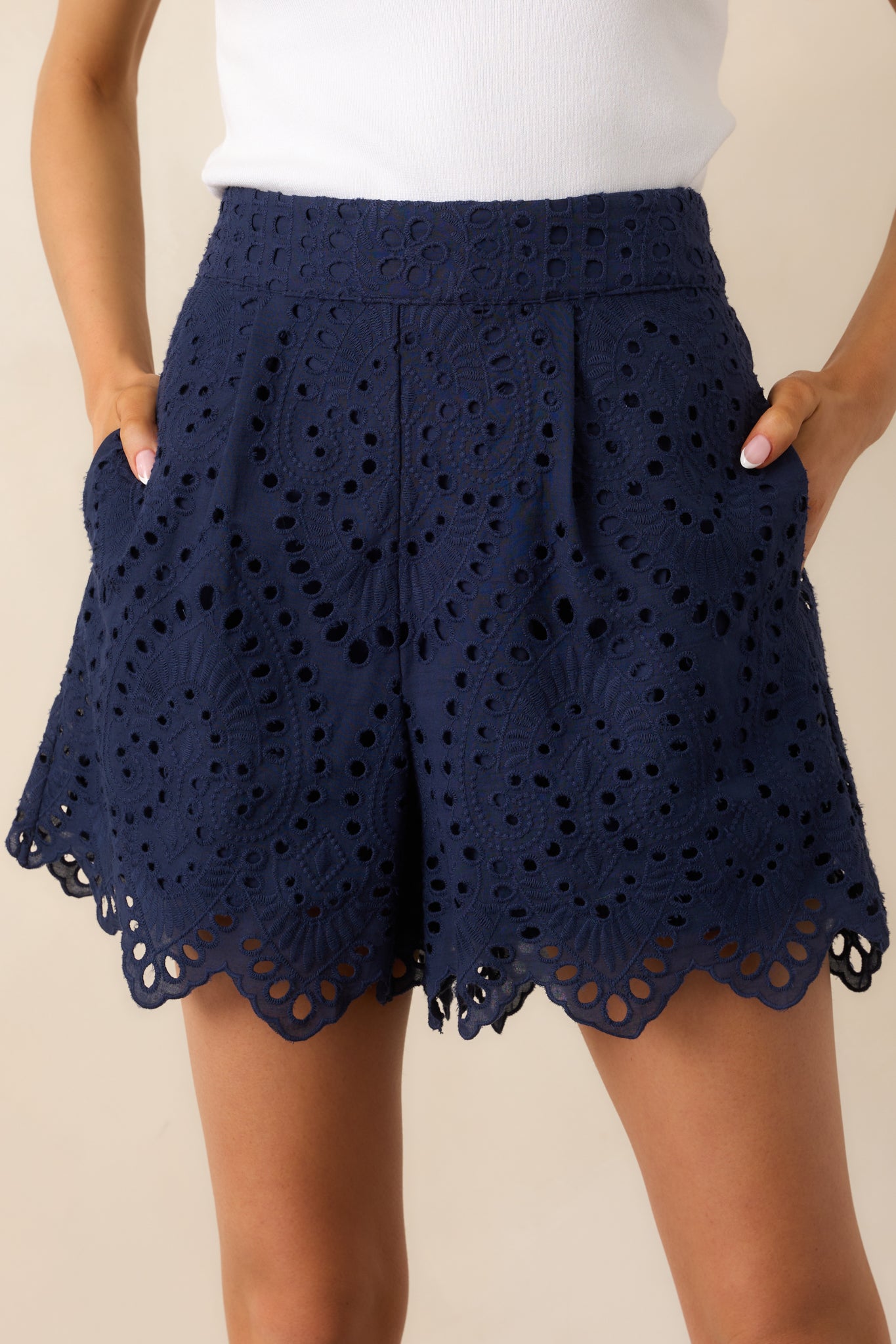 A close-up shot of one of the functional pockets, showcasing its seamless integration into the pleated design and the embroidery overlay.