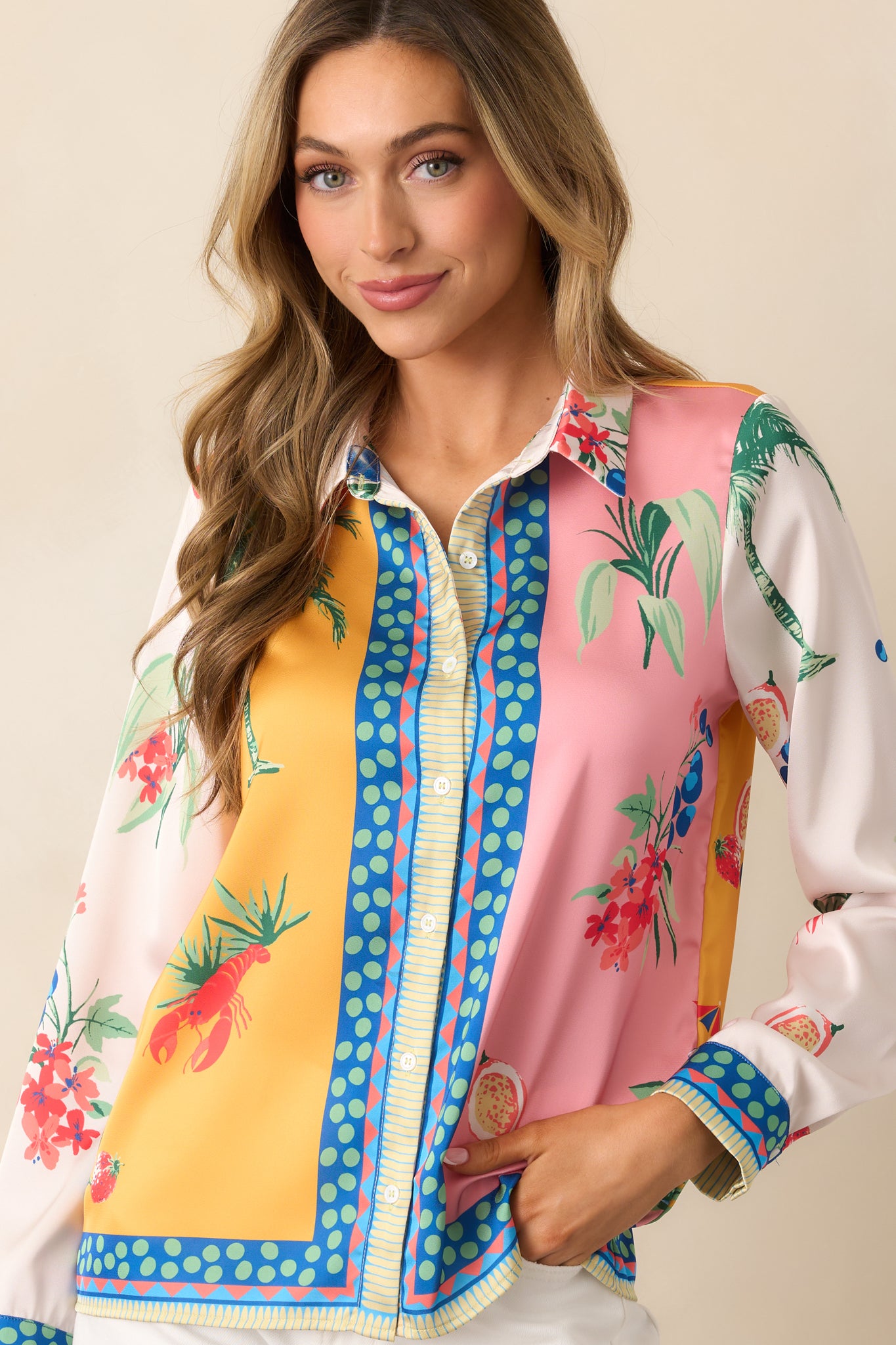 A yellow satin top with a colorblock design, showcasing various prints and coastal-inspired icons.
