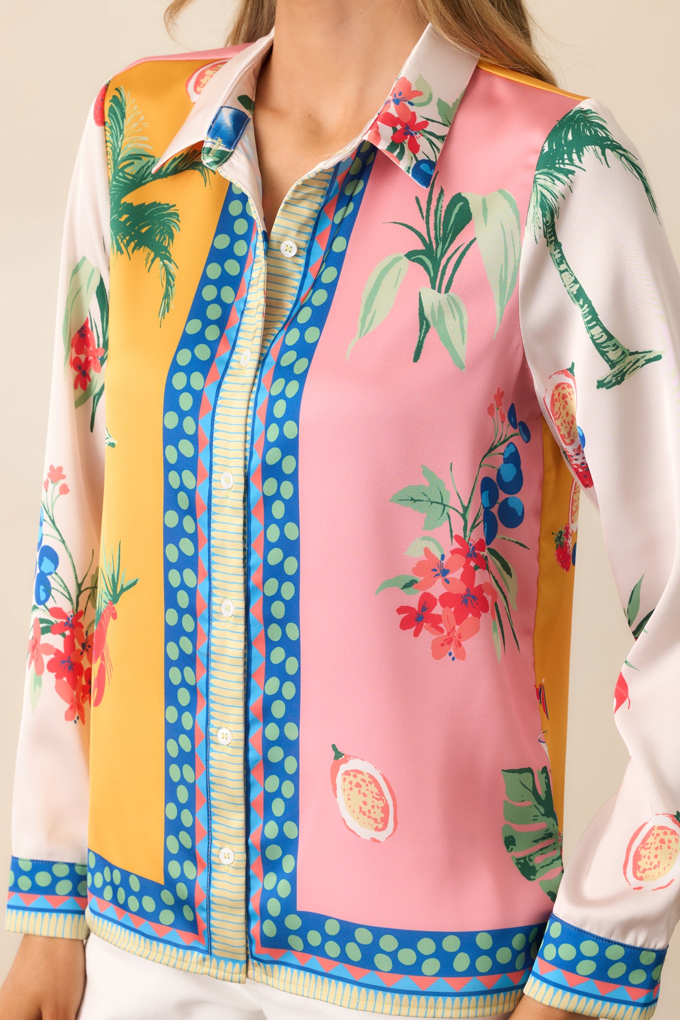 The long sleeves of the yellow top, complete with buttoned cuffs, add a refined touch to the breezy, coastal-inspired design.