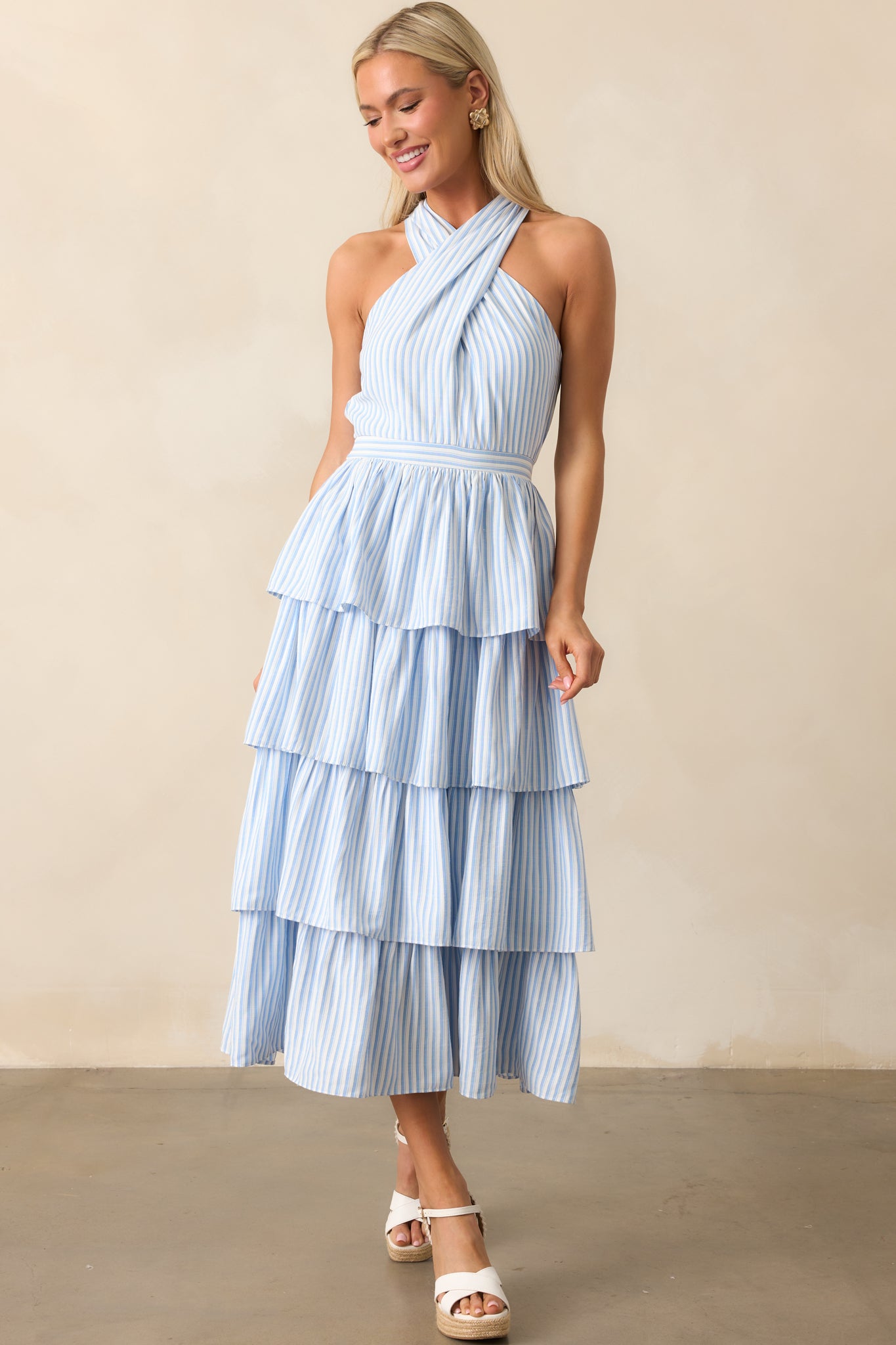 A light blue dress with a criss-cross halter neckline and a tiered skirt, offering a graceful, flowing silhouette.