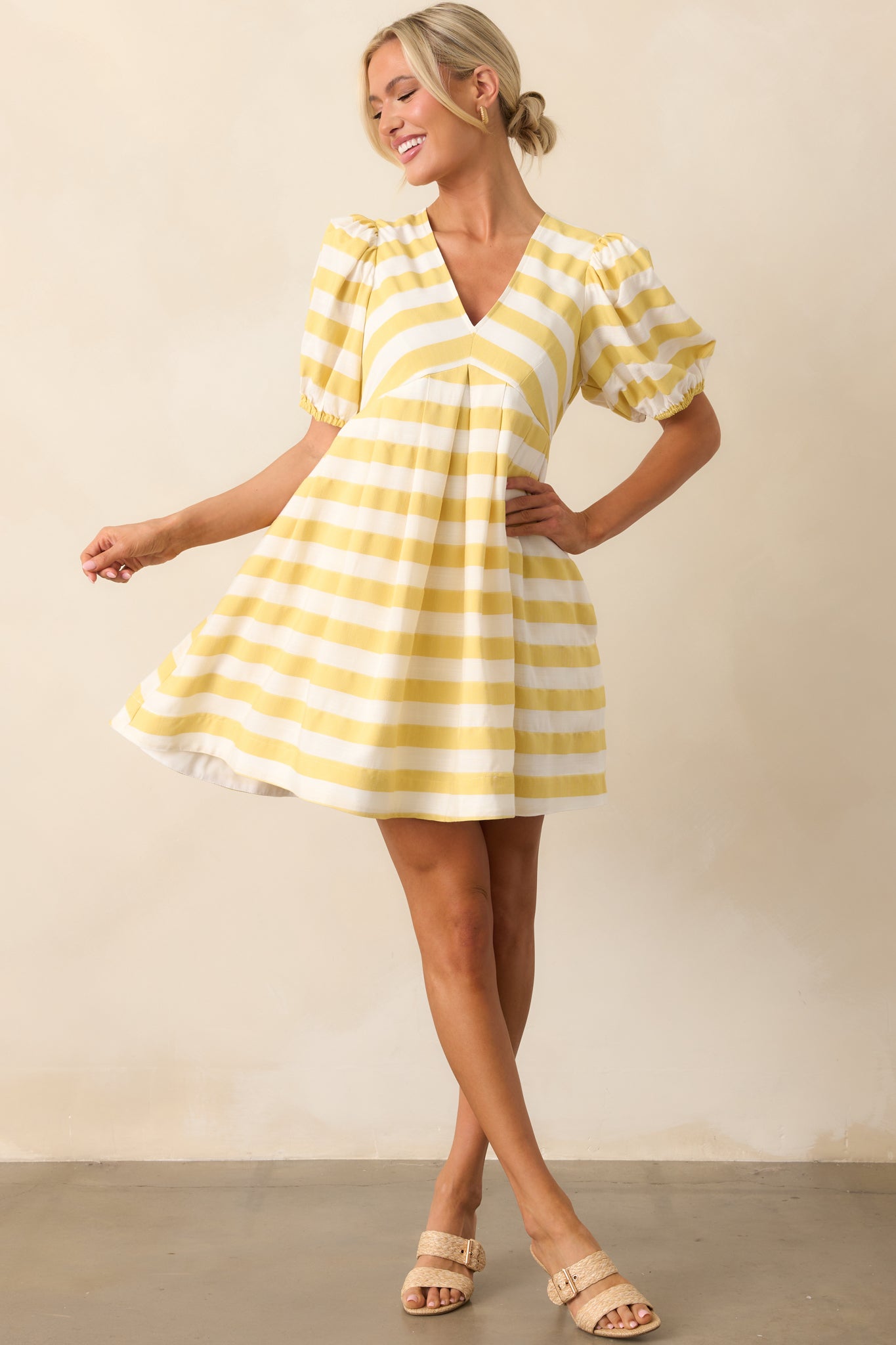 A yellow mini dress with a V-neckline, short puff sleeves, and a flowy skirt for an effortless look.