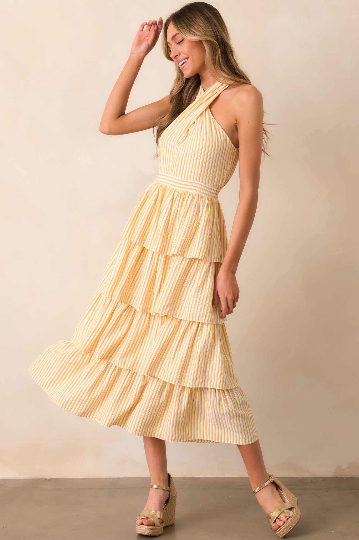 A cheerful yellow dress with a criss-cross halter neckline and a tiered skirt, perfect for a sunny day.