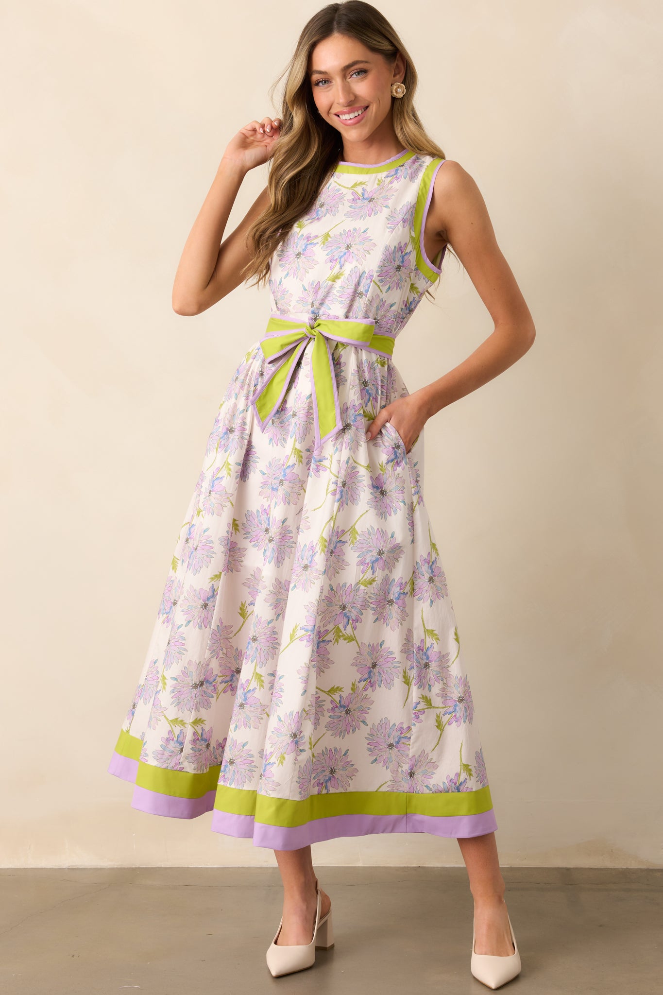 A charming midi dress blooming with a lavender aster flower print, accented by bright chartreuse trim. The sleeveless design and crew neckline offer an effortless silhouette.
