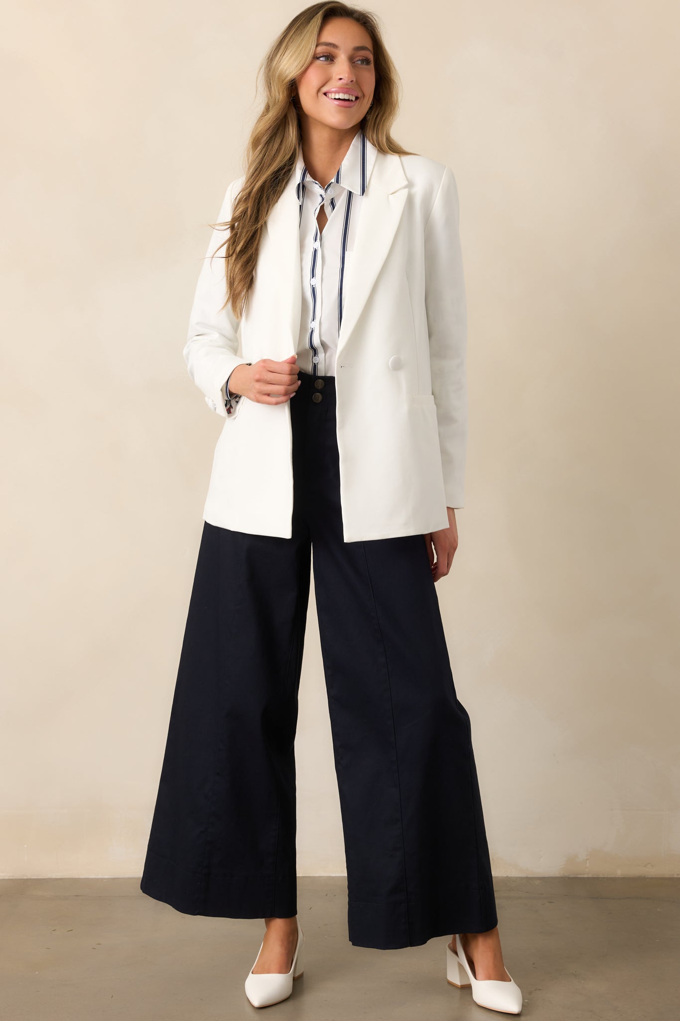 Navy high-waisted pants with a button zipper closure, wide-leg fit, and functional rectangular hip pockets, displayed from a front-facing angle.
