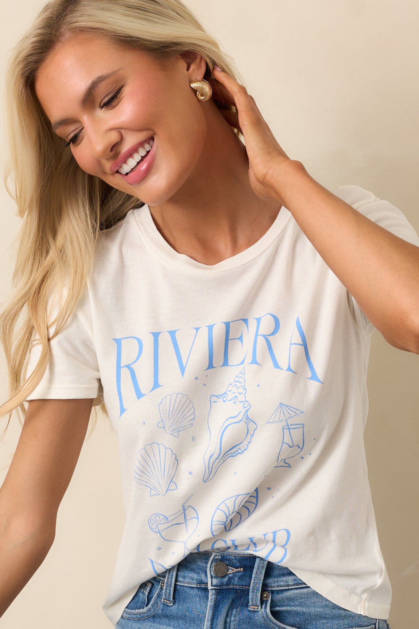 A full view of the top featuring a crew neckline and a Riviera Beach Club-inspired graphic, made from 100% cotton jersey fabric, with short sleeves for a relaxed, casual look.