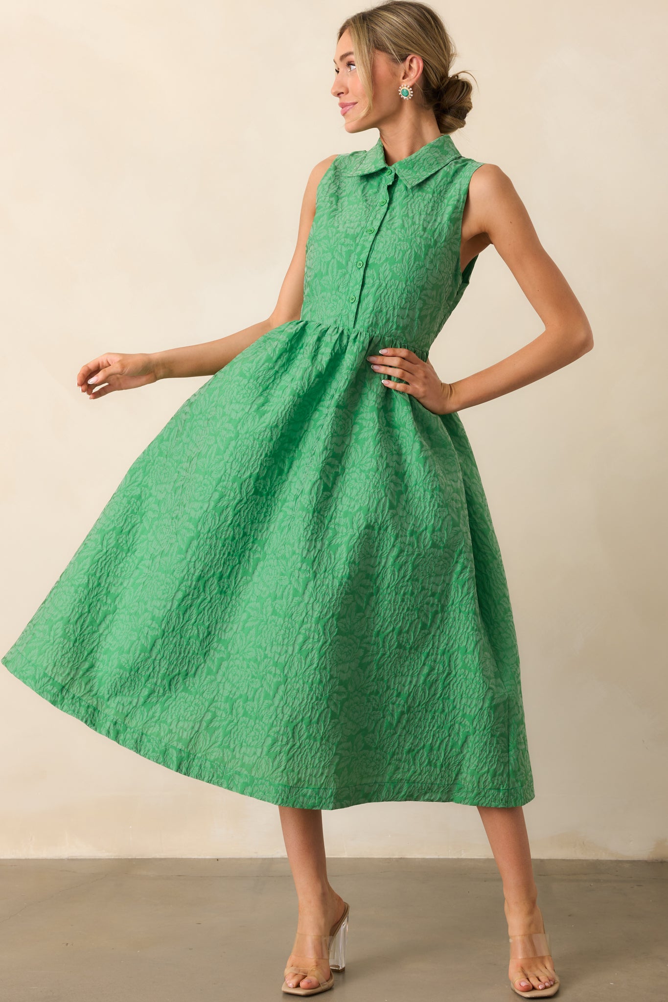 A green midi dress with a collared neckline, sleeveless design, and a structured skirt for a polished look.