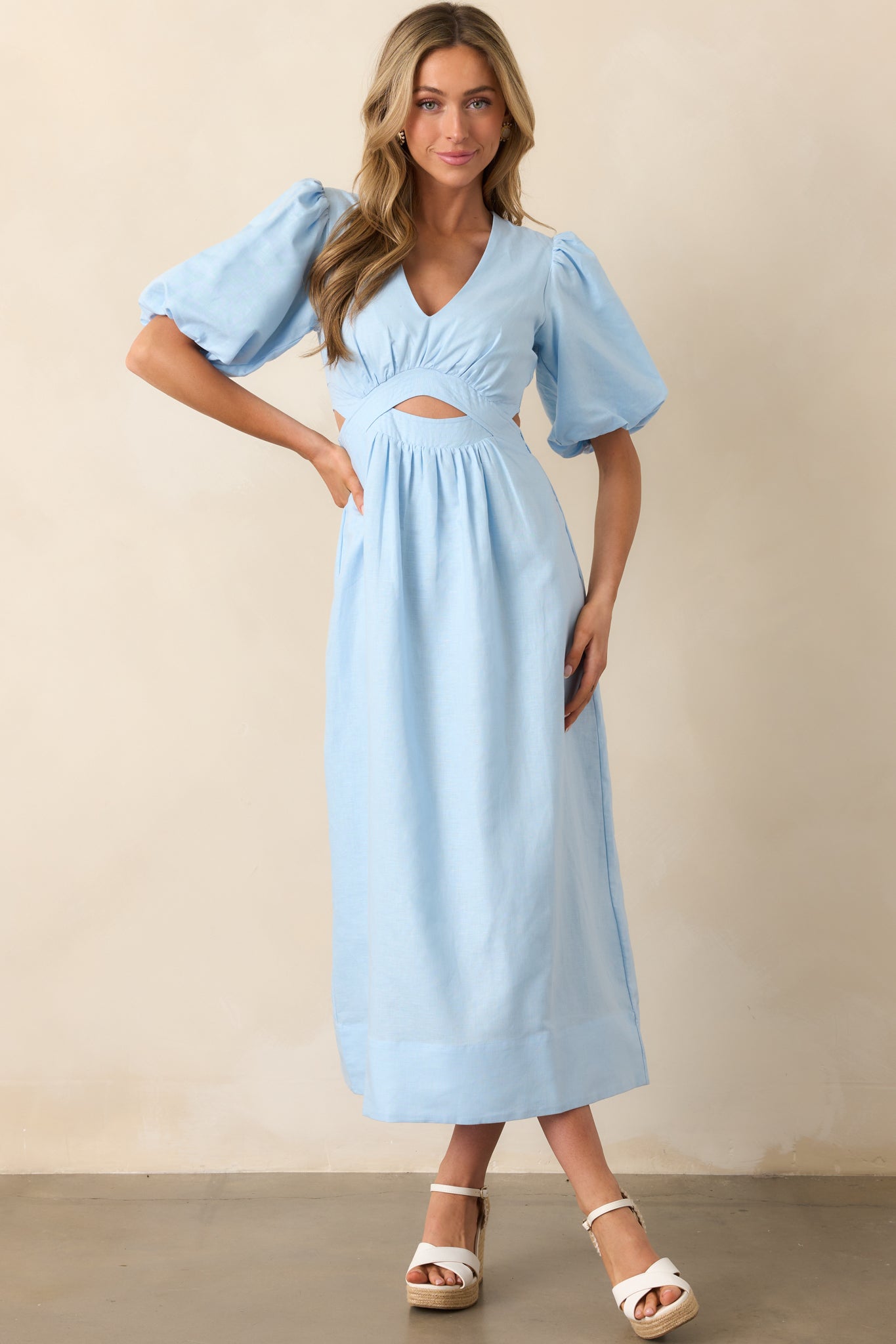 The sky blue dress with short puff sleeves, an elastic waist insert in the back, and a v-neckline that brings elegance to any occasion.