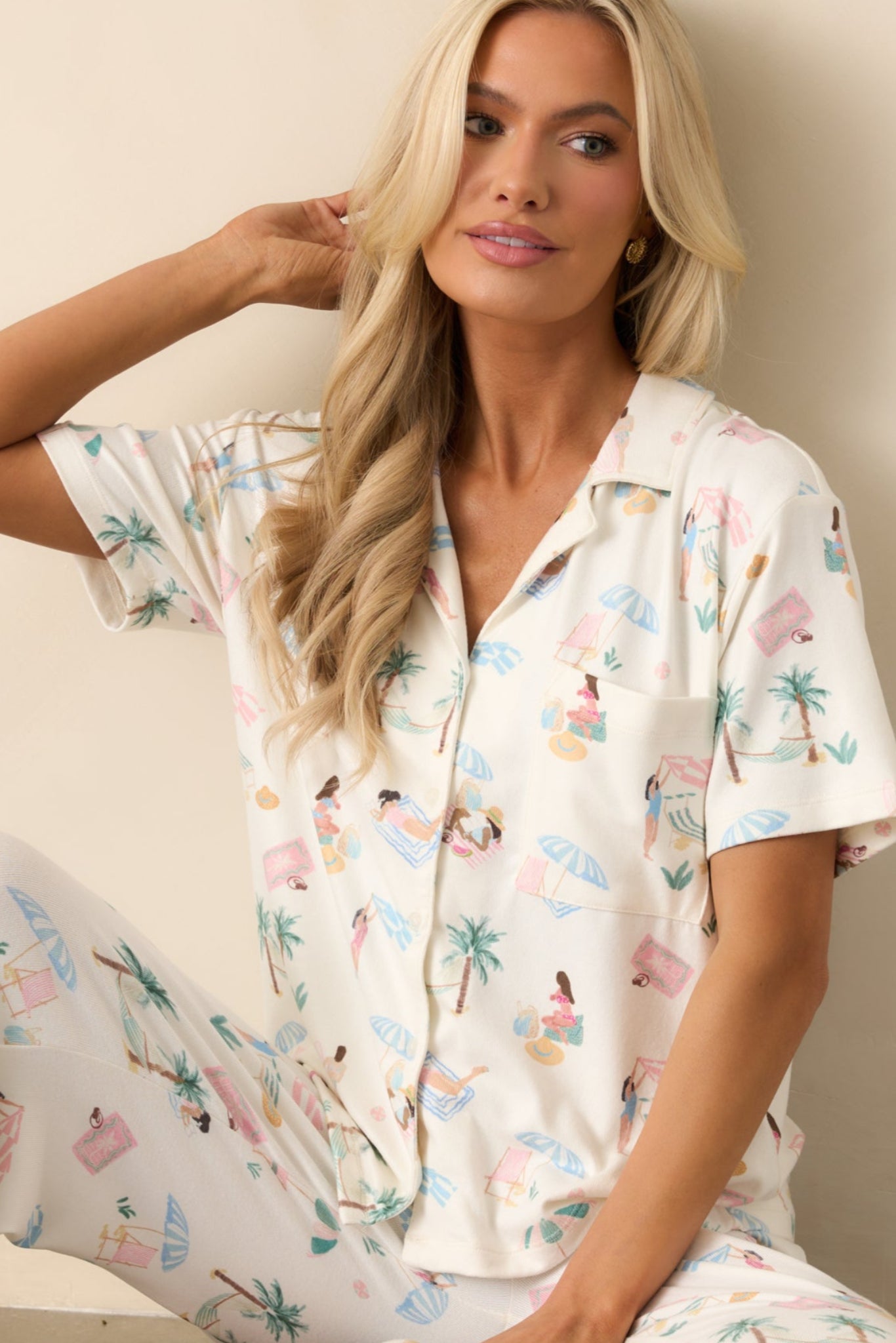 This ivory pajama top is made from ultra-soft jersey fabric, featuring a collared neckline with notch lapels and a functional button front. The relaxed fit and breezy beach print add to its cozy appeal.