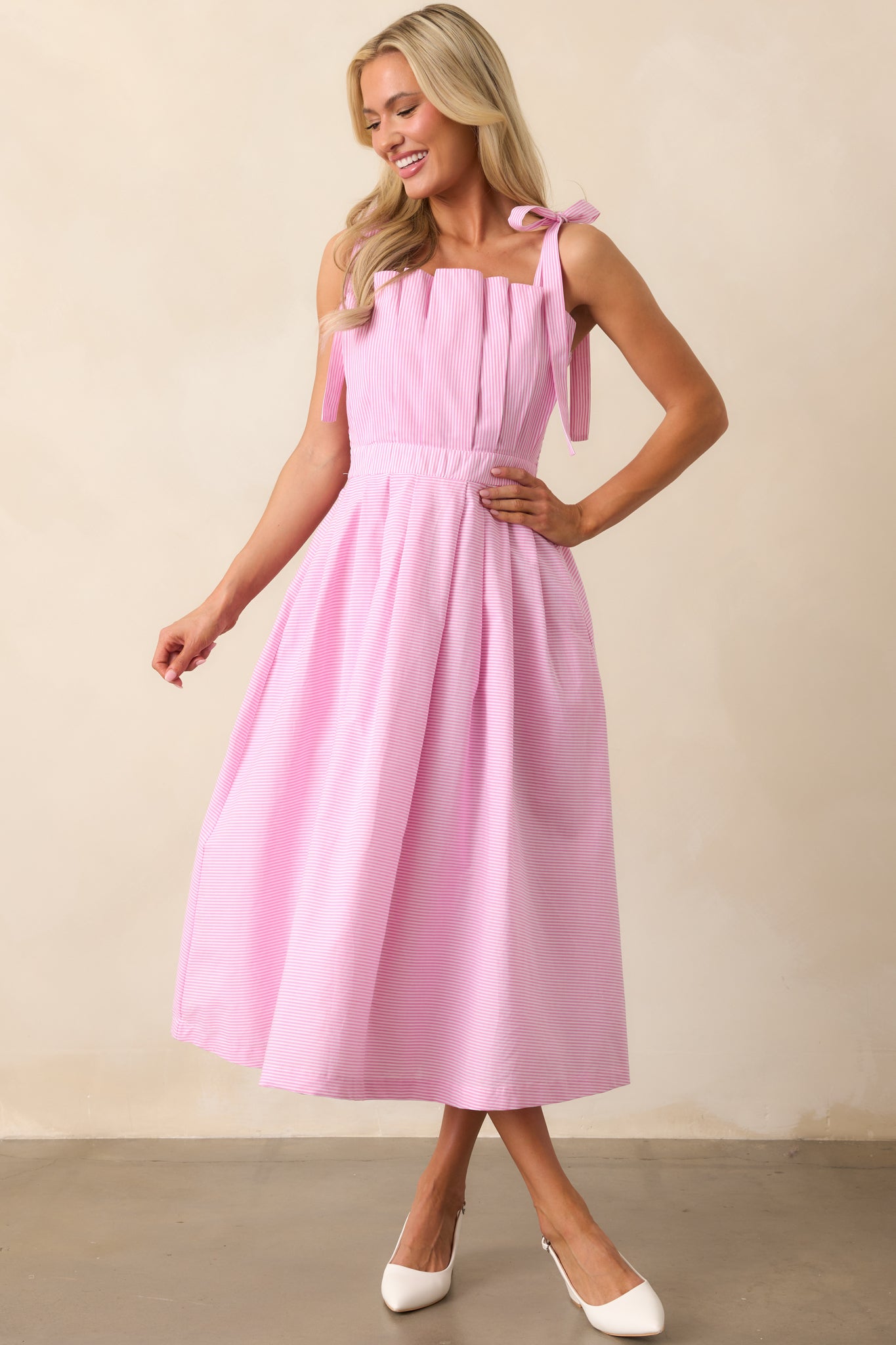 A front-facing view of the peony pink stripe midi dress, showcasing its pleated bodice and flowing silhouette.